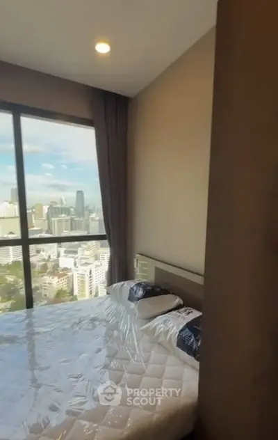 Modern bedroom with city view from high-rise apartment window
