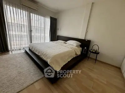 Spacious modern bedroom with large window and minimalist decor