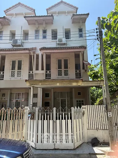 Charming three-story townhouse with gated entrance and classic architectural design.