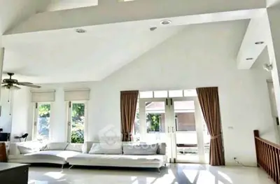 Spacious modern living room with high ceilings and large windows for natural light.