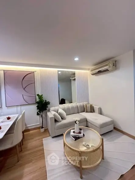 Modern living room with stylish decor, featuring a cozy sectional sofa, elegant dining area, and contemporary artwork.