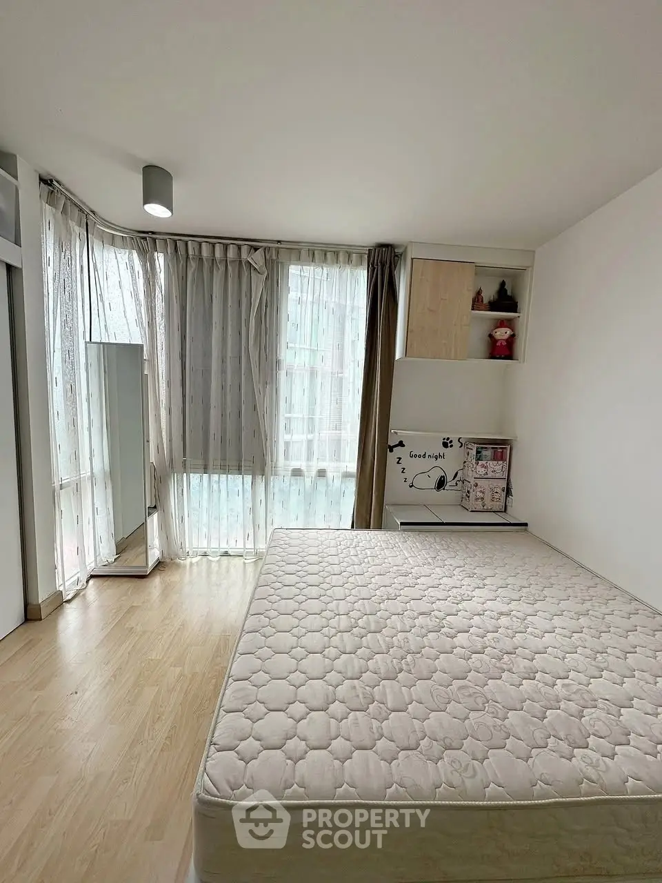 Spacious bedroom with large windows and natural light, featuring a minimalist design and cozy atmosphere.