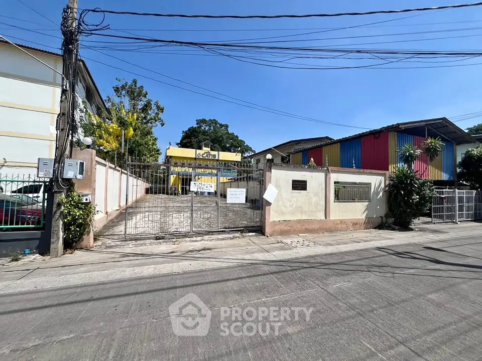 Spacious gated property with colorful building exterior and ample parking space.