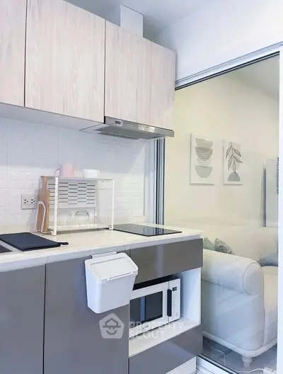 Modern kitchen with sleek cabinetry and built-in microwave, featuring a minimalist design and open layout.