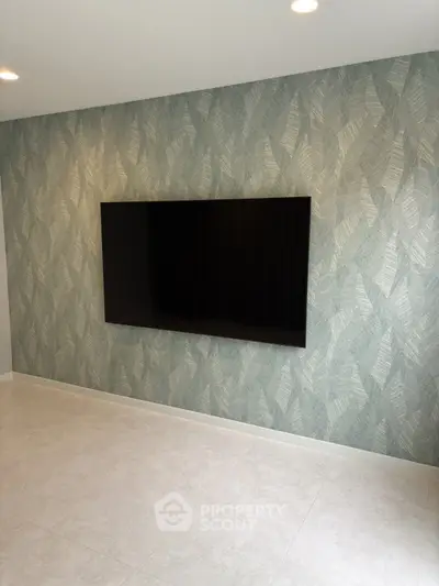 Modern living room with stylish wallpaper and mounted flat-screen TV