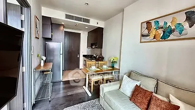 Modern living room with cozy sofa and stylish kitchen in open layout apartment.