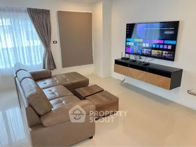 Modern living room with sleek leather sofa and wall-mounted TV