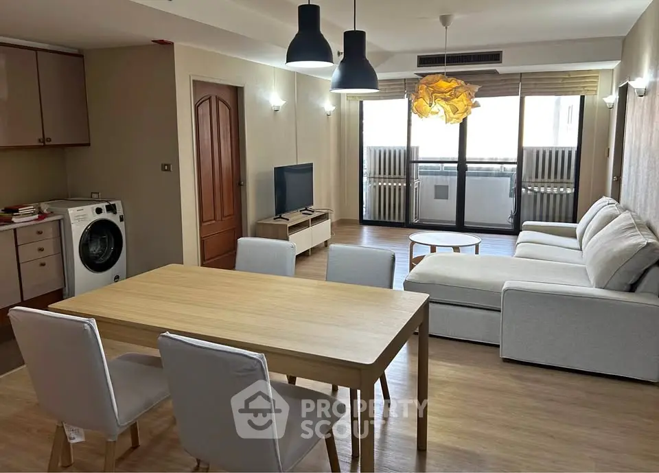 Spacious living room with modern furniture and natural light, featuring a cozy dining area and open layout.