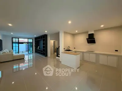 Spacious modern open-plan living room and kitchen with sleek design and ample natural light.