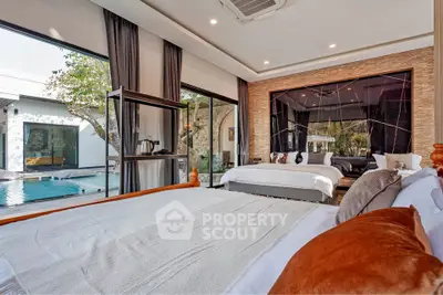 Luxurious bedroom with pool view and modern decor in a stylish home.