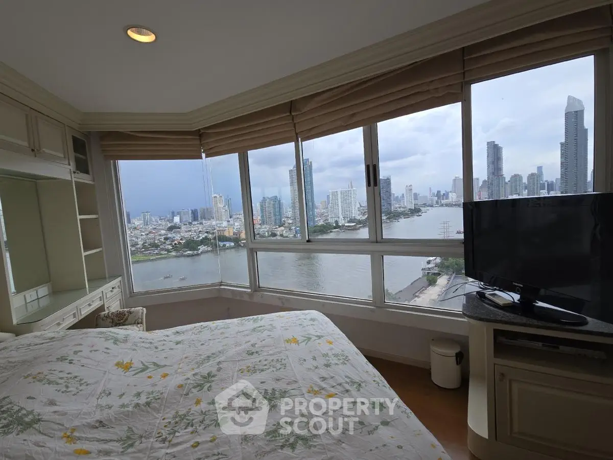 Stunning bedroom with panoramic city and river views, featuring large windows and elegant decor.