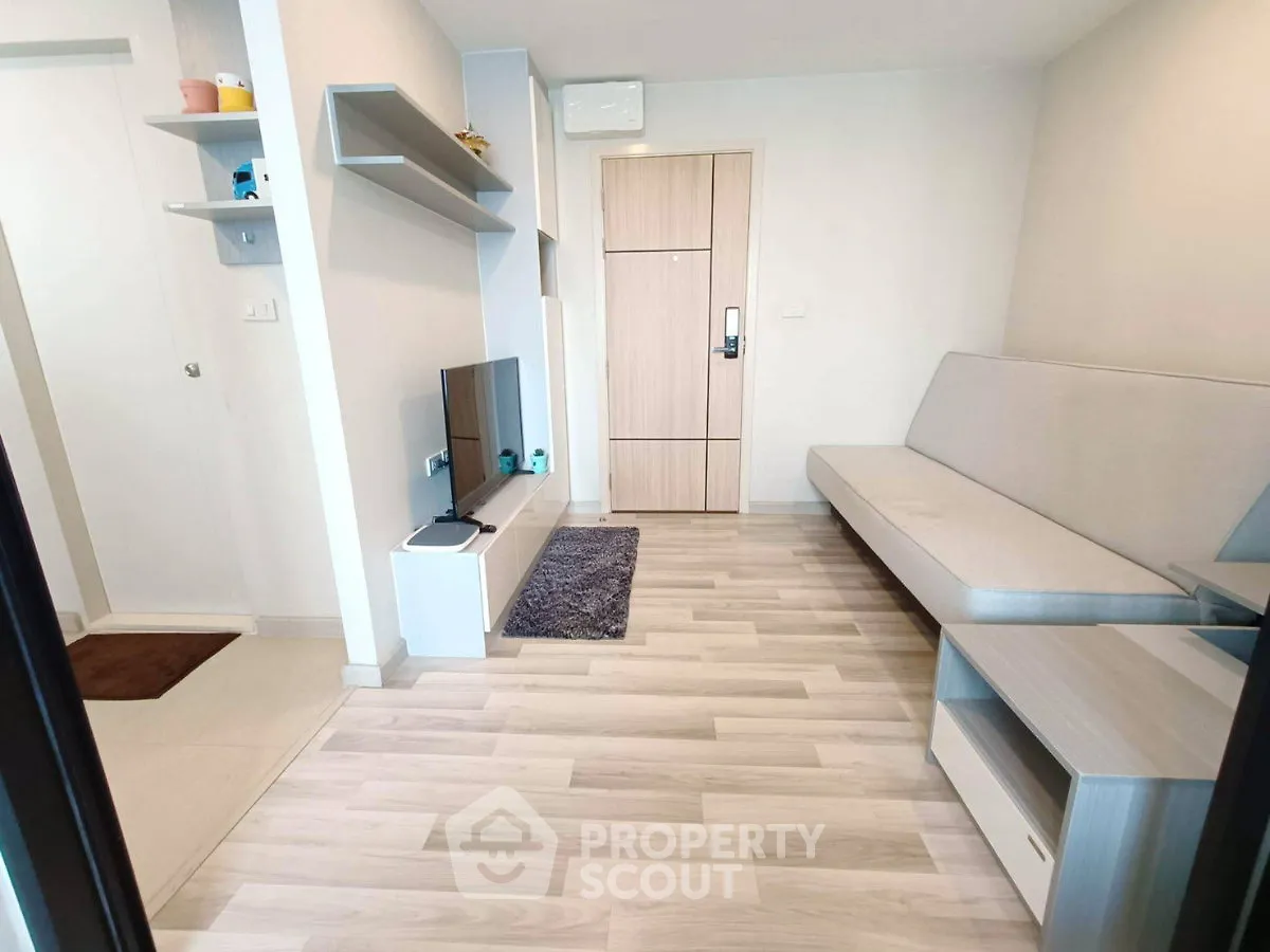 Modern living room with sleek furniture and light wood flooring in a contemporary apartment.