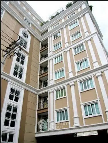 Elegant multi-story residential building with classic architectural design and large windows.