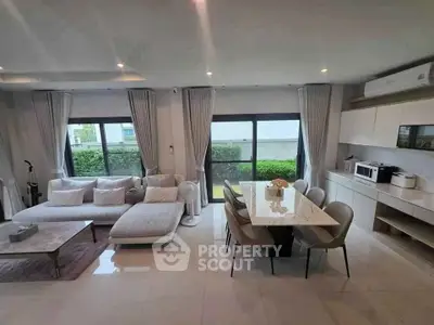 Spacious modern living room with dining area, featuring elegant furniture and large windows.