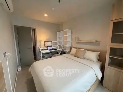 Cozy bedroom with modern study area and ample storage in a stylish apartment.