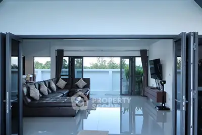 Spacious modern living room with large windows and sleek furniture