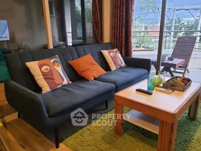 Cozy living room with modern sofa and balcony view, perfect for relaxation.