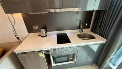 Modern compact kitchen with sleek cabinetry, induction cooktop, and integrated appliances.