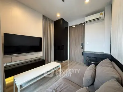 Modern living room with sleek design, featuring a large TV, comfortable sofa, and stylish decor.