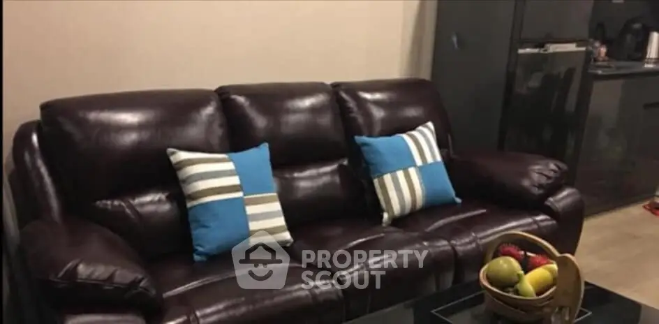 Cozy living room with leather sofa and modern kitchen setup