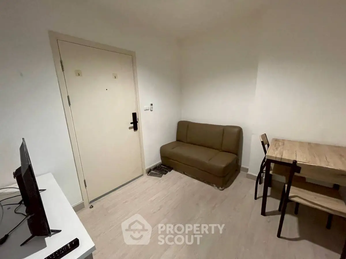 Cozy living room with compact sofa and dining table, ideal for small apartments