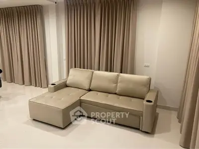 Modern living room with beige sectional sofa and elegant curtains