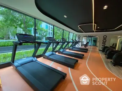 Modern gym with treadmills and large windows in luxury residential building