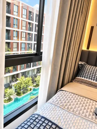 Modern bedroom with pool view in luxury apartment complex