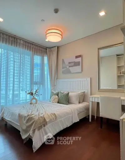 Elegant bedroom with modern decor and large windows offering city views, perfect for urban living.