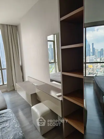 Modern bedroom with city view, featuring sleek furniture and floor-to-ceiling windows.