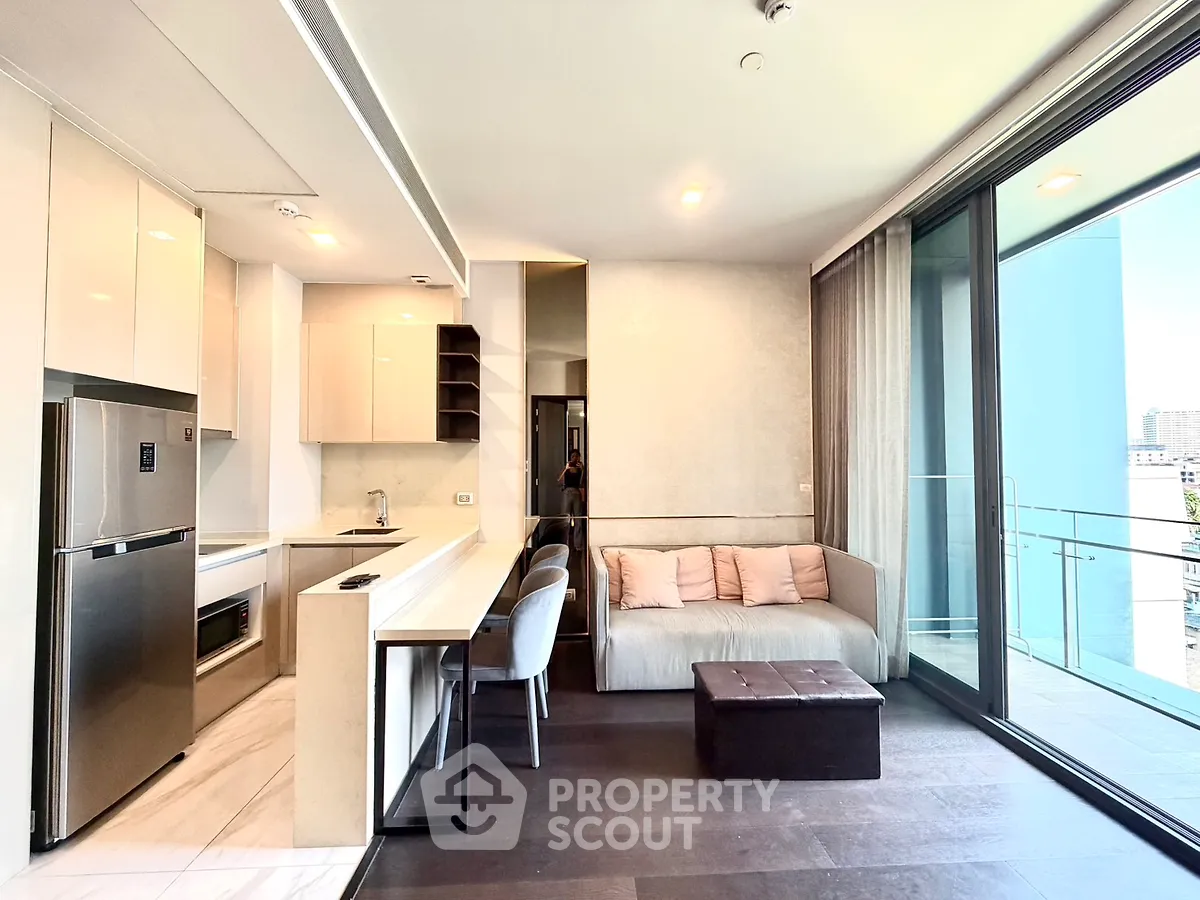 Modern open-layout kitchen and living room with large balcony and city view.