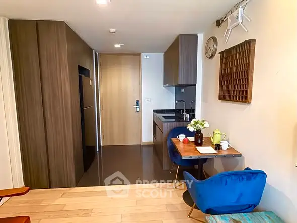 Modern kitchen with sleek cabinetry and cozy dining area in stylish apartment.