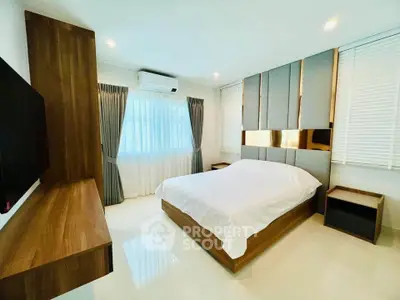 Modern bedroom with stylish decor and natural light, featuring a cozy bed and elegant furnishings.
