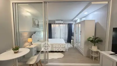 Modern bedroom with glass partition, elegant decor, and cozy ambiance in a stylish apartment.