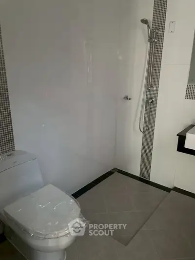 Modern bathroom with sleek shower and toilet in minimalist design