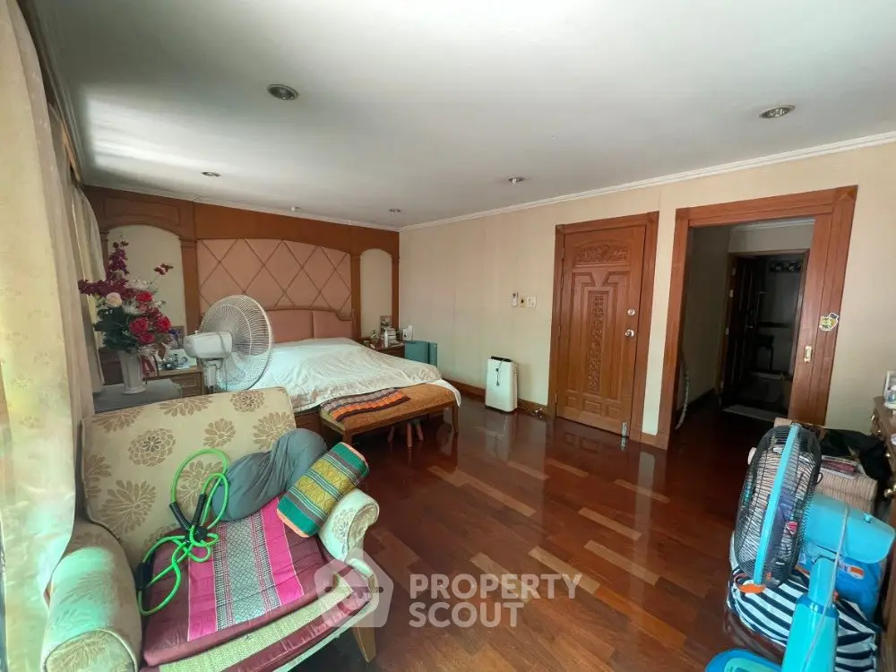 Spacious bedroom with wooden flooring and elegant decor