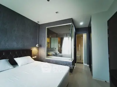 Modern bedroom with stylish decor and large mirror, featuring a comfortable bed and sleek design.