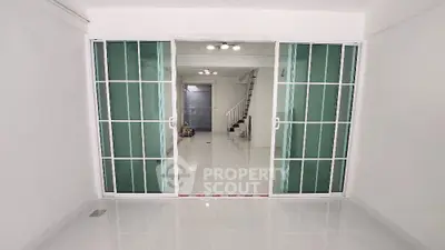 Spacious modern interior with sliding glass doors and sleek staircase, perfect for contemporary living.