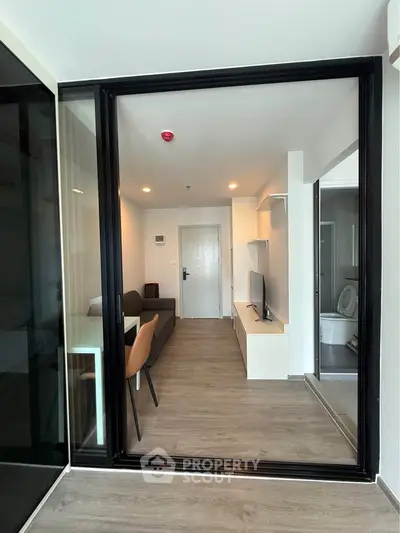 Modern living room with sleek furniture and open layout, featuring a cozy seating area and stylish decor.