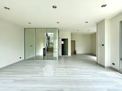 Spacious modern living area with glass partition and sleek flooring