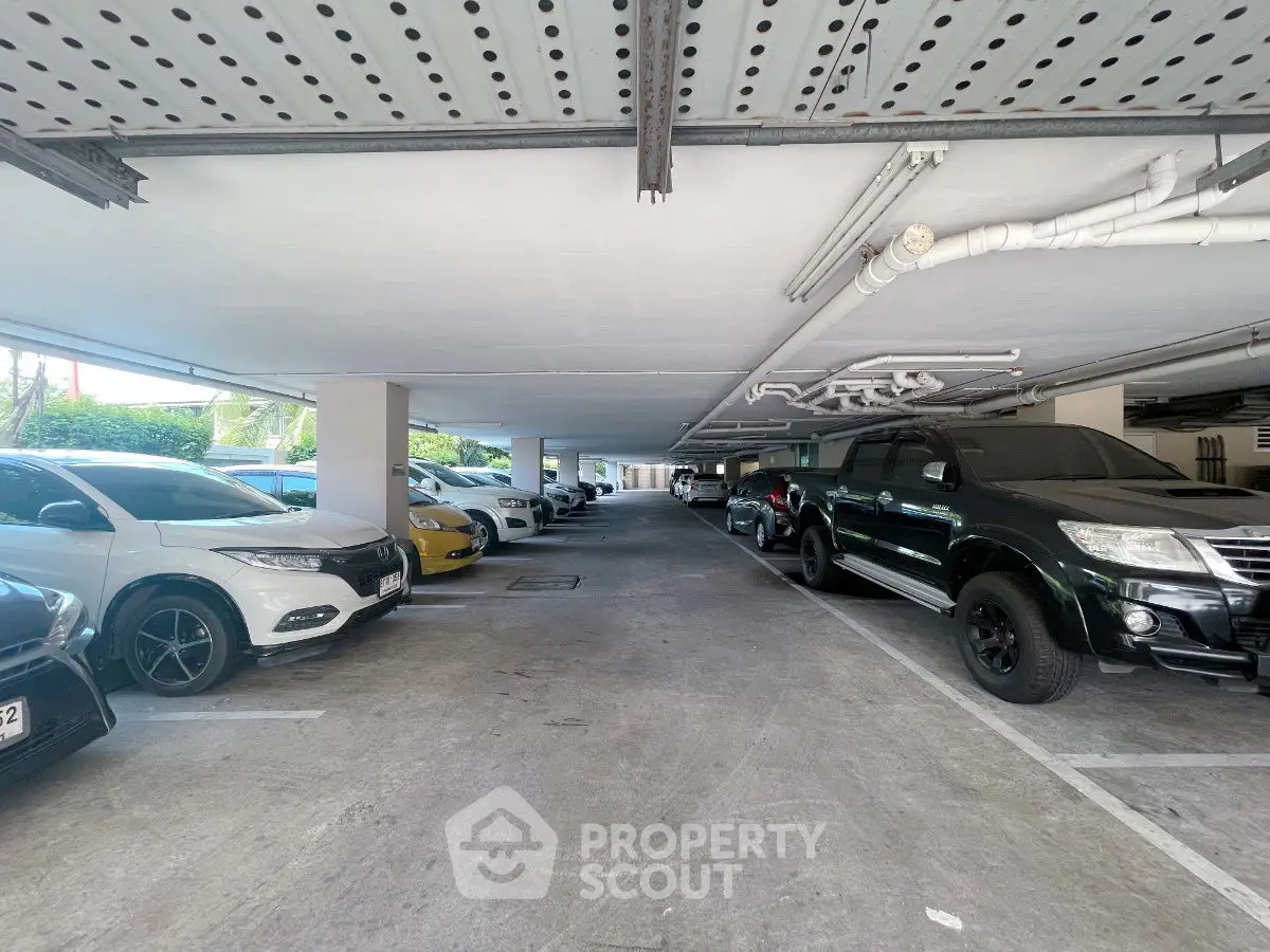 Spacious covered parking area with multiple vehicles in a modern building.