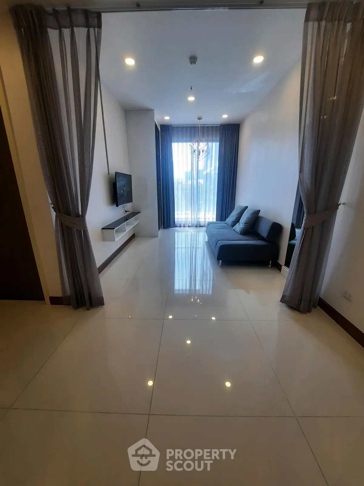 Modern living room with sleek design, large windows, and elegant curtains in a contemporary apartment.