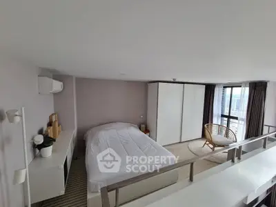 Modern loft bedroom with large windows and stylish decor in a high-rise apartment.