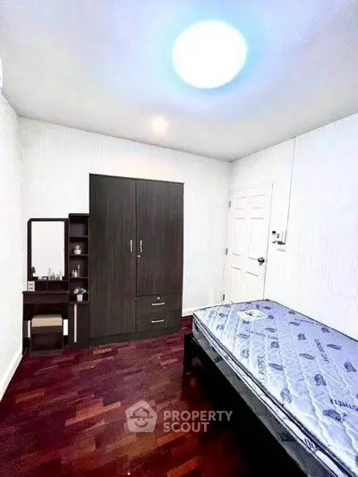 Cozy bedroom with wooden flooring and minimalist furniture design