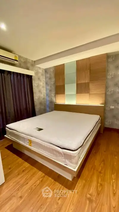 Modern bedroom with stylish decor and wooden flooring, featuring a comfortable bed and ambient lighting.