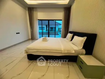 Luxurious bedroom with modern design and balcony view in upscale property.