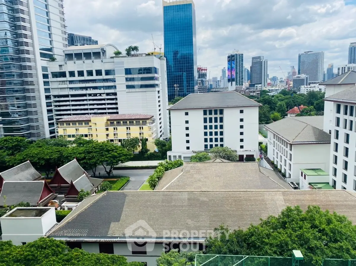 Stunning cityscape view from a high-rise building showcasing modern architecture and lush greenery.