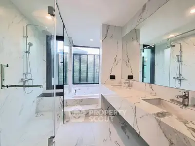 Luxurious modern bathroom with marble finishes and spacious shower area.
