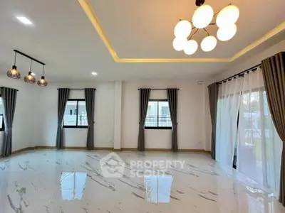 Spacious modern living room with elegant lighting and large windows.