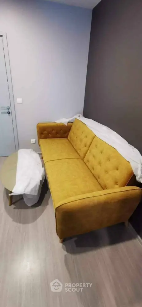 Modern living room with stylish yellow sofa and sleek coffee table.